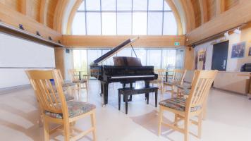 Image of grand piano with chairs circling it