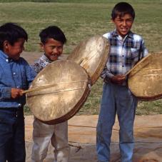 July 1968, in Tulita, Carl Yakeleya, Charlie McCauley and Roderick Clement learn to celebrate with the Dene drum.