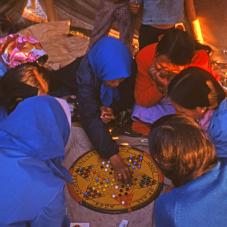 Behchokǫ, July 1975. Christine Chinkon, Adele Rabesca, Rosalind Mantla and friends play a game of Chinese checkers.