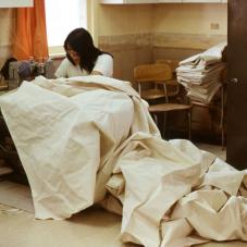 The canvas shop in Fort McPherson (Teetl'it Zheh) has been in operation since 1971. Annie Margaret Kay sews a tent in 1982.