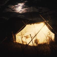 The winter home of a Dene family, lit by oil lamp.